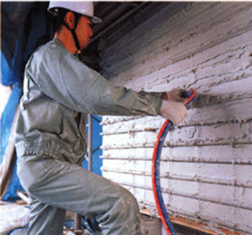 作業員が補強材を塗り込んでいる施工状況