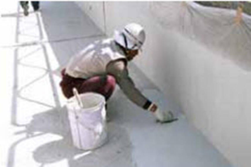 作業員が水路側壁の断面修復作業を行っている様子