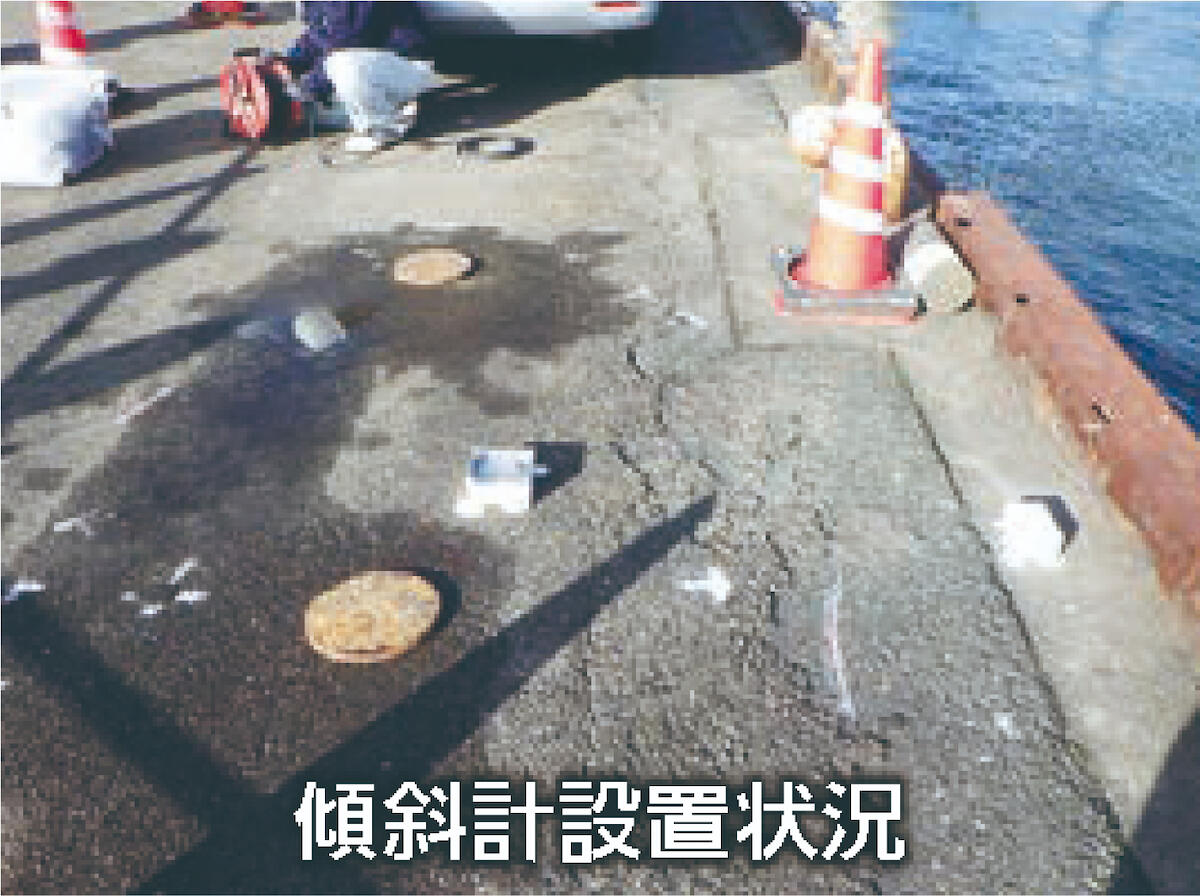 護岸上で充填孔位置を確認し設置作業を行う様子